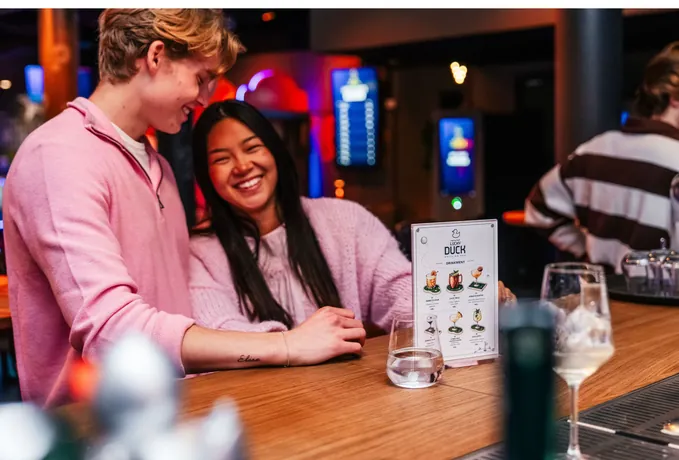 Gjester med drinkmenyen i baren